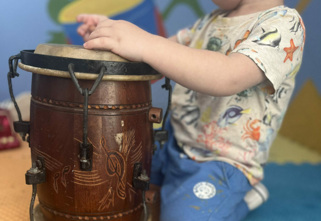 niño de preescolar tocando el tambor. arte en la escuela